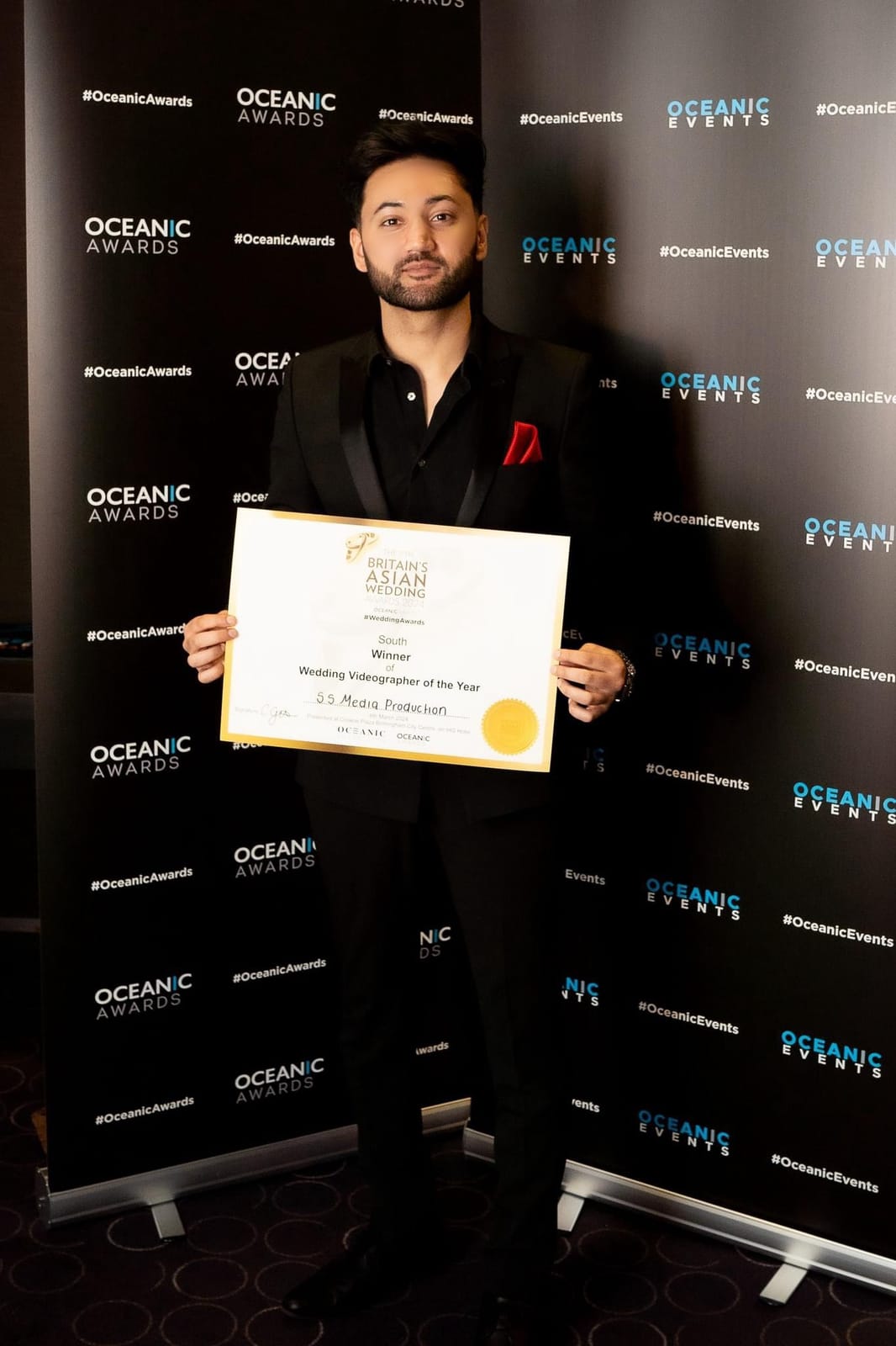 Shaz, founder of S.S Media Production, holding the company's certificate at Britain's Asian Wedding Awards 2024.